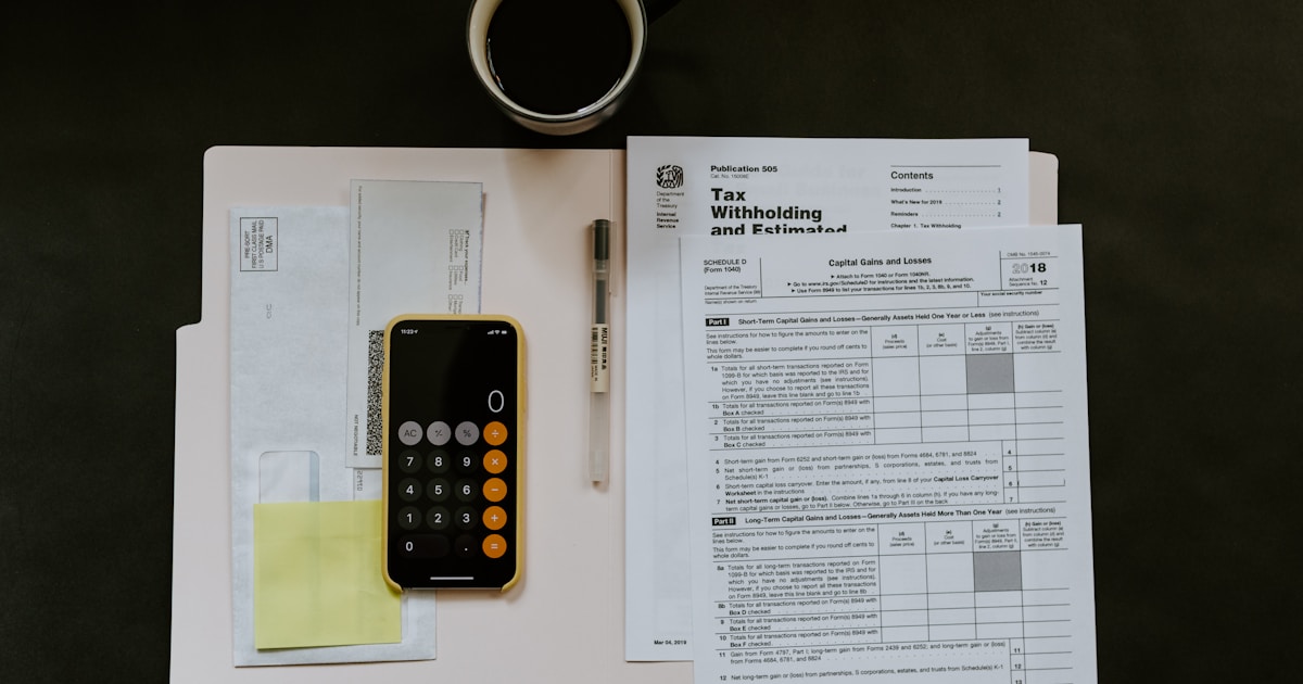 Person reviewing home loan paperwork with calculator and house keys