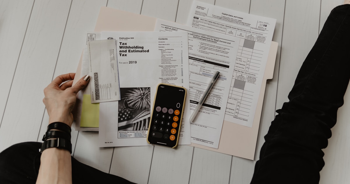 Person planning a savings budget with calculator and notebook