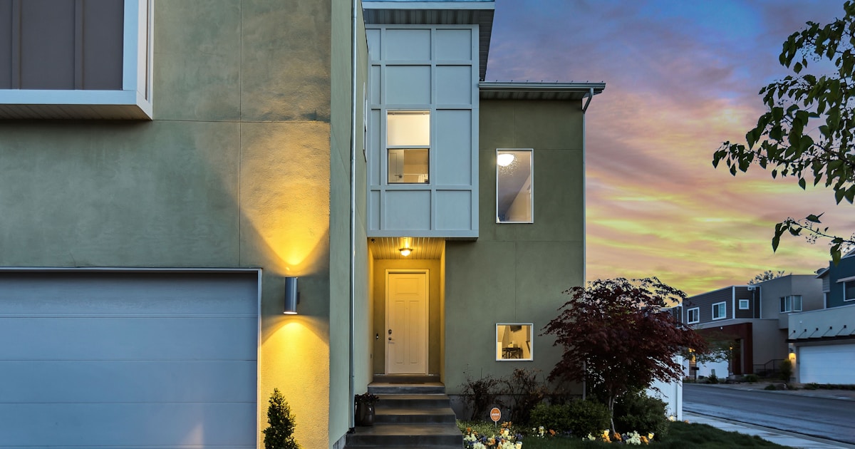 Exterior view of a modern home at sunset with a landscaped front garden